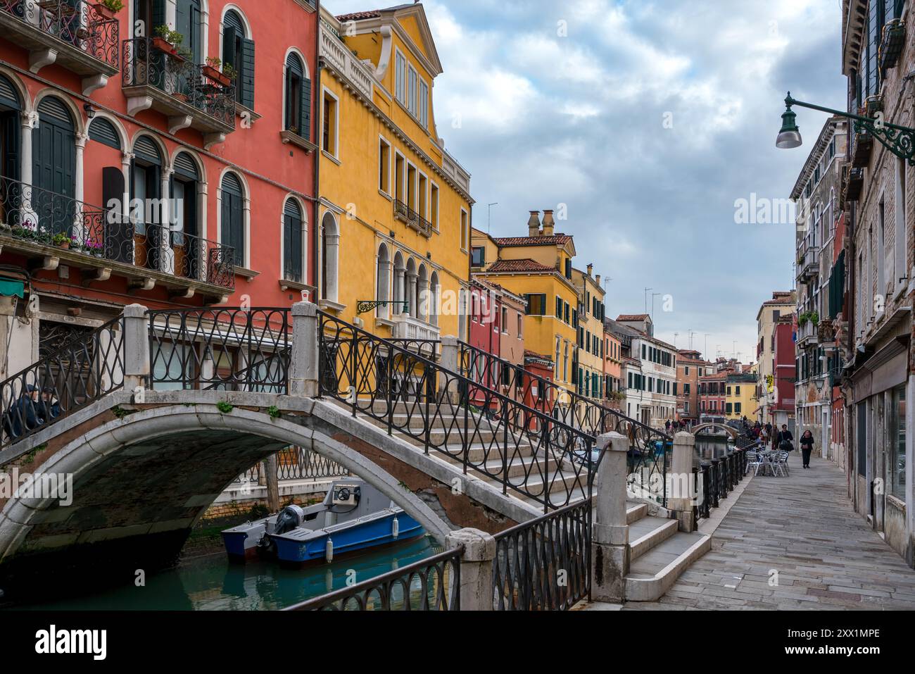 Via Venezia con case colorate e un ponte sul canale con le barche, Venezia, sito patrimonio dell'umanità dell'UNESCO, Veneto, Italia, Europa Foto Stock