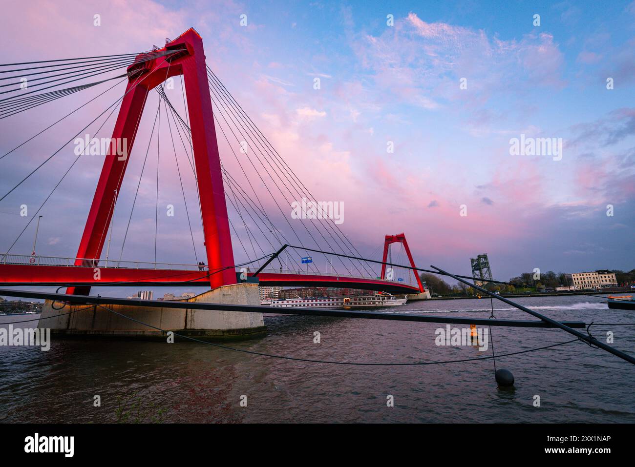 Willemsbrug moderno ponte sospeso rosso al tramonto con un cielo rosa in una serata estiva, Rotterdam, Paesi Bassi, Europa Foto Stock