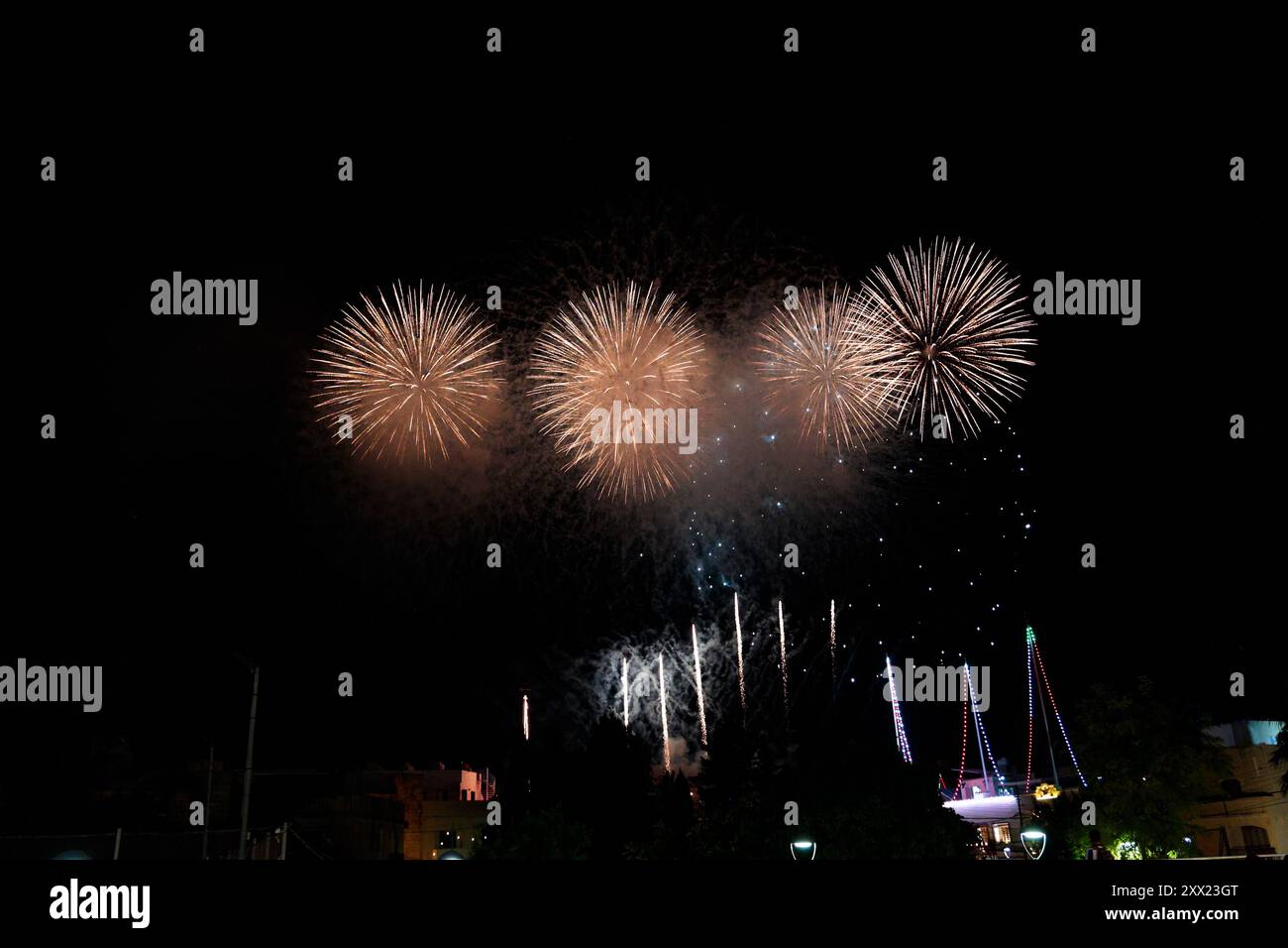 Un vivace spettacolo di fuochi d'artificio che illuminano il cielo notturno durante un evento celebrativo. Festa della Trasfigurazione di Cristo. Lija, Malta. Foto Stock