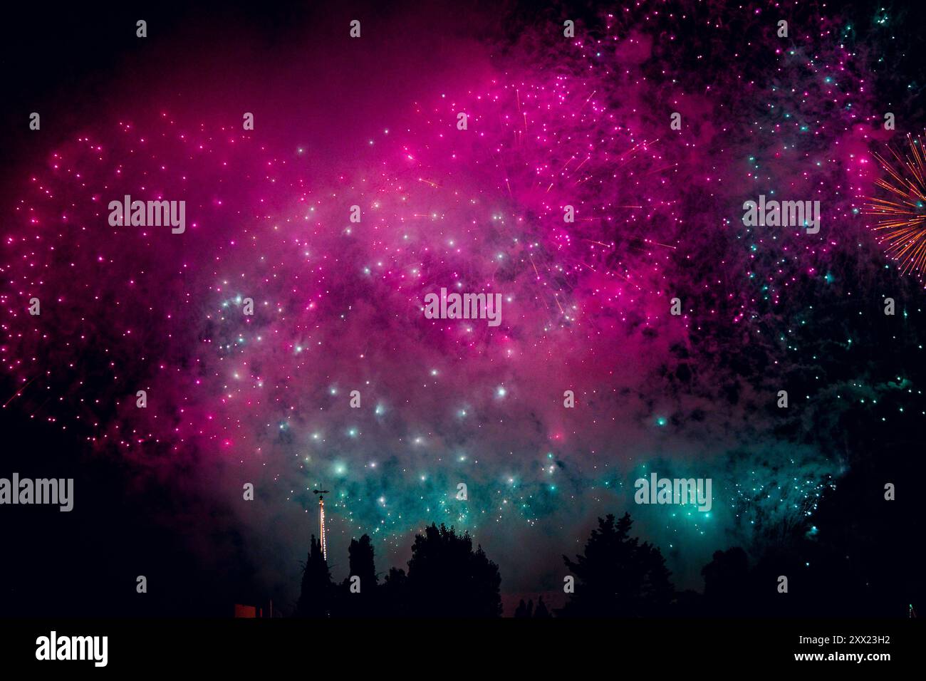 I vivaci fuochi d'artificio illuminano il cielo notturno con sfumature rosa e blu. Celebrazione della Festa della Trasfigurazione di Cristo. Lija, Malta Foto Stock