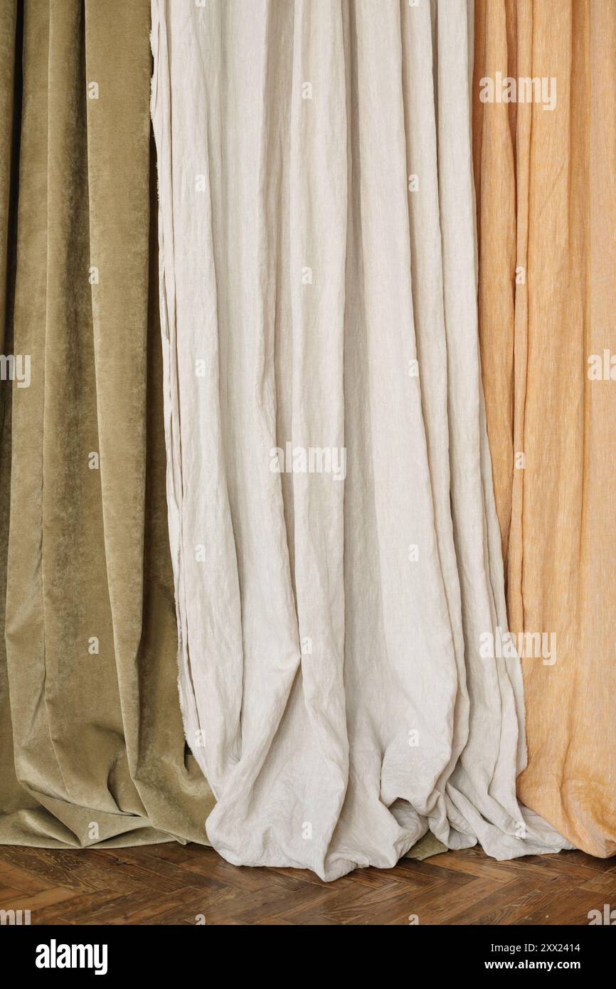 Primo piano delle tende Olive, grigio chiaro e beige sospese fianco a fianco Foto Stock