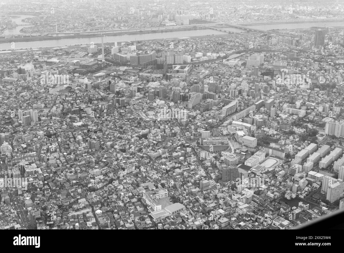 Vista aerea in bianco e nero di Tokyo, in Giappone, che mostra il fitto paesaggio urbano e il fiume che attraversa l'estesa città. Foto Stock