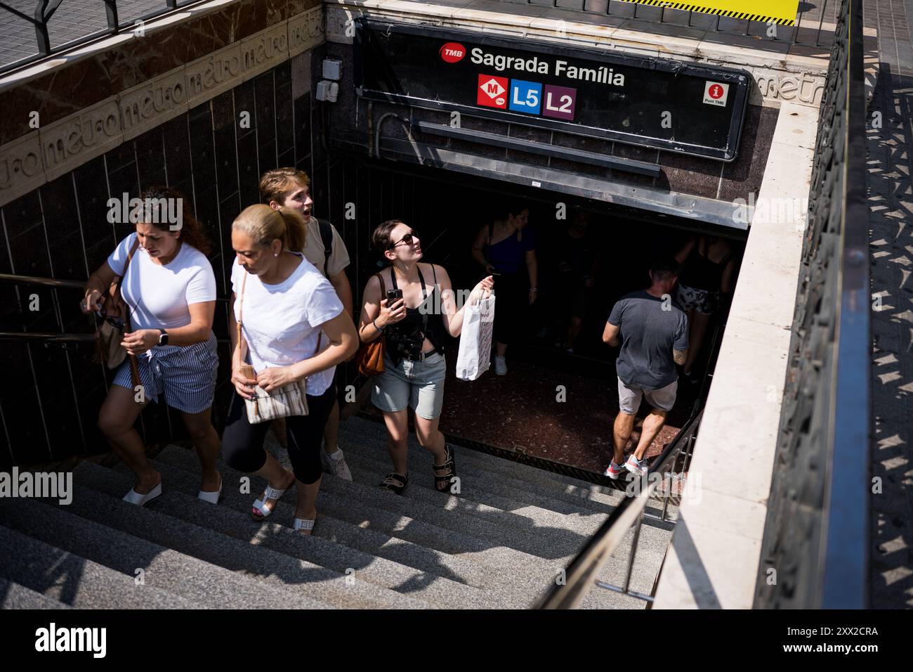 Barcellona, Spagna. 21 agosto 2024. La gente arriva alla stazione della metropolitana Sagrada Familia. Con più di 18 milioni di turisti che si prevede visiteranno Barcellona nel 2024, la città sta lottando per trovare un equilibrio tra i benefici economici del turismo durante la stagione turistica e la necessità di mantenere la città vivibile per i residenti locali, che stanno mostrando ostilità verso il turismo di massa e lo sfruttamento della città da parte dell'industria turistica. Credito: SOPA Images Limited/Alamy Live News Foto Stock