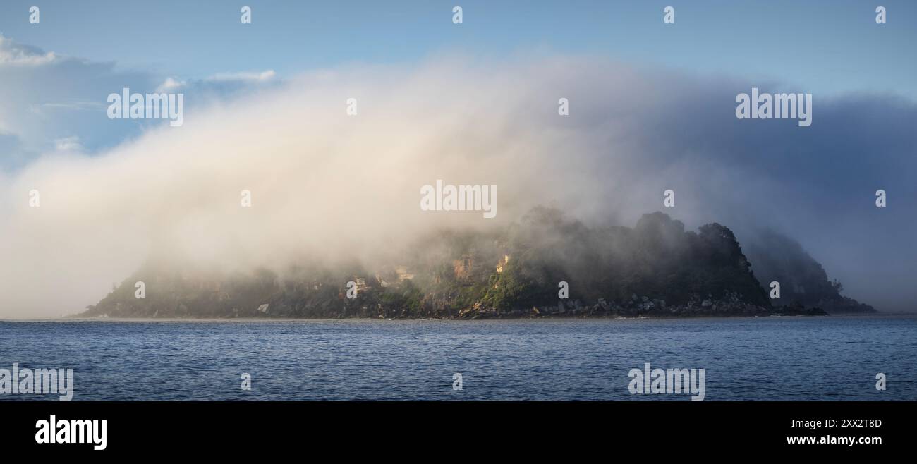 una nuvola di nebbia e nebbia sull'isola dei leoni sulla costa centrale del nsw in australia Foto Stock