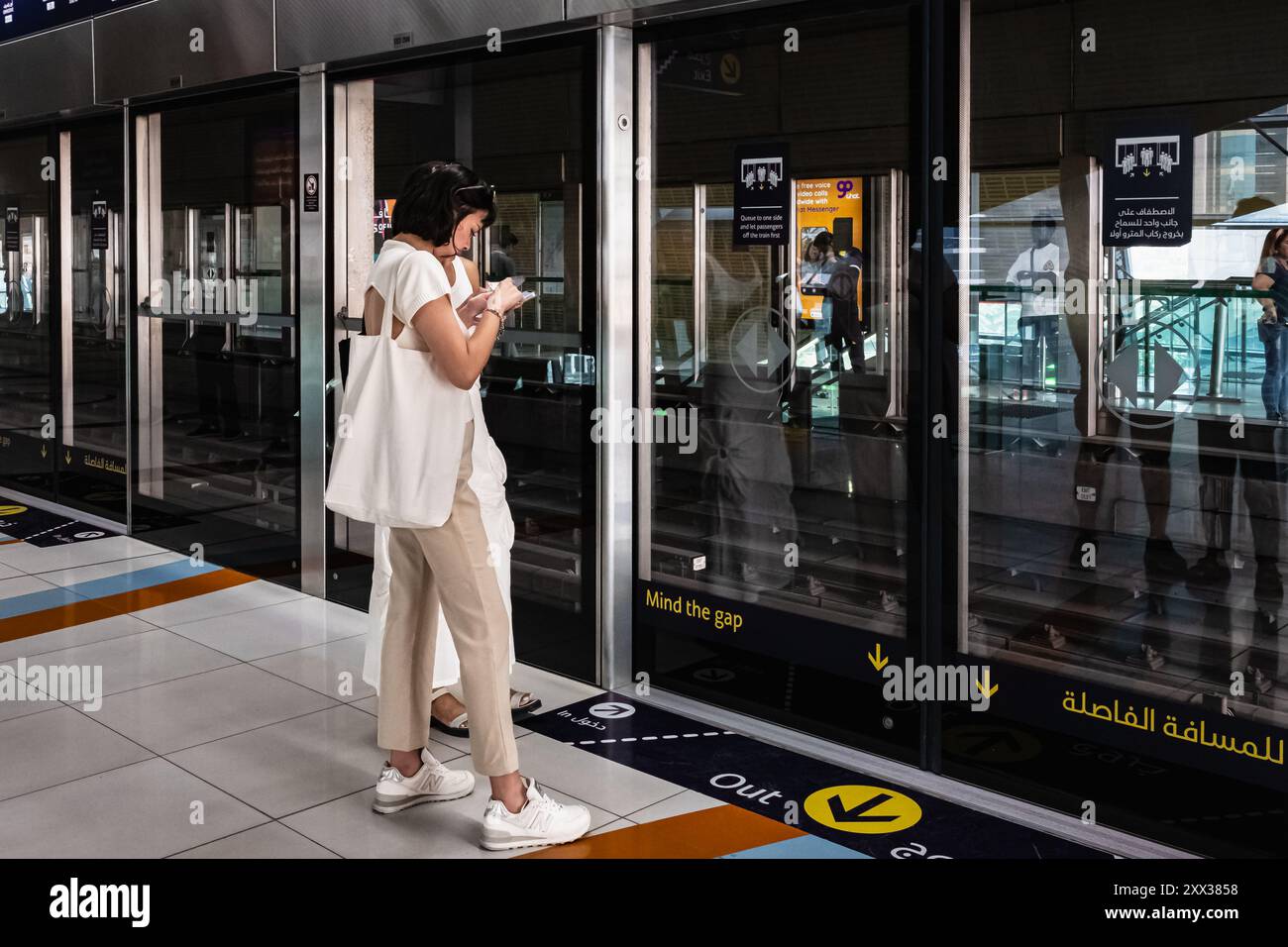 Stazione della metropolitana. Donna viaggiatrice che si imbarca alla stazione ferroviaria di collegamento che collega le stazioni della metropolitana di Dubai negli Emirati Arabi Uniti. L'ingresso alla cabina donne e bambini di Dubai Foto Stock