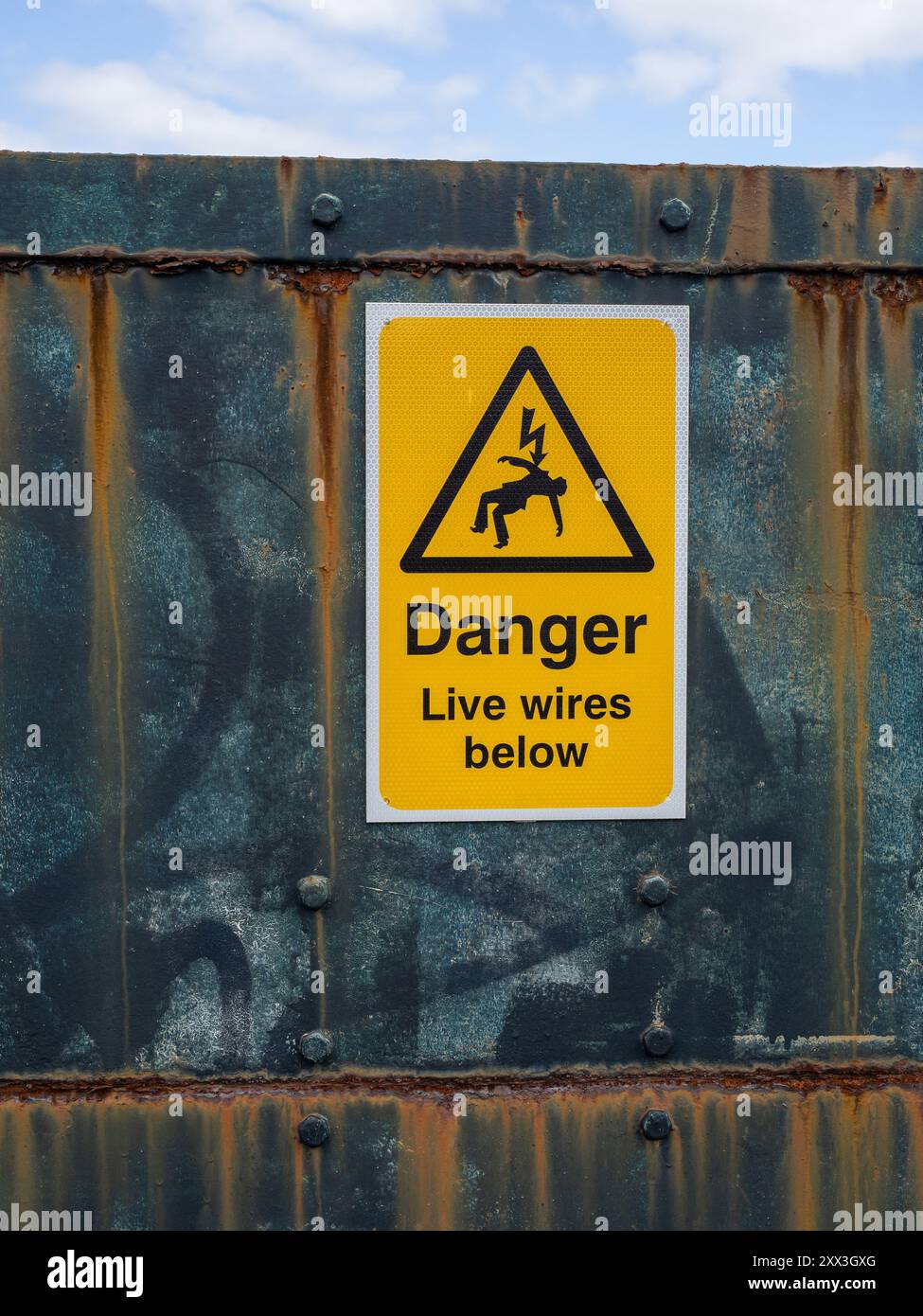 Pericolo di cavi sotto il cartello di avvertimento giallo con logo, su un ponte ferroviario a Blisworth Arm, Northamptonshire, Regno Unito Foto Stock