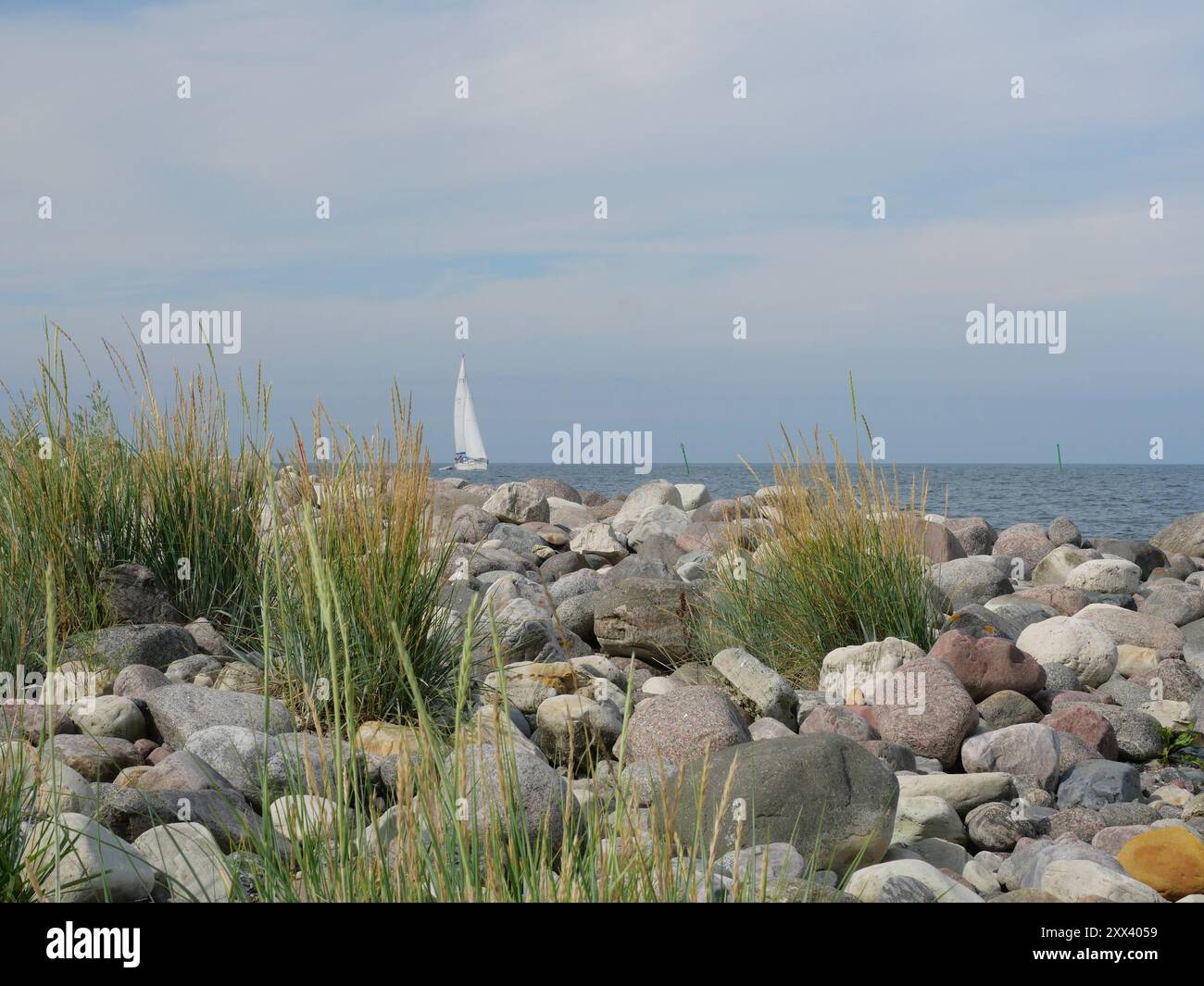 una barca a vela in lontananza risveglia il desiderio di viaggiare. Affacciato sul mare con un ambiente tranquillo. Un'espressione di silenzio Foto Stock