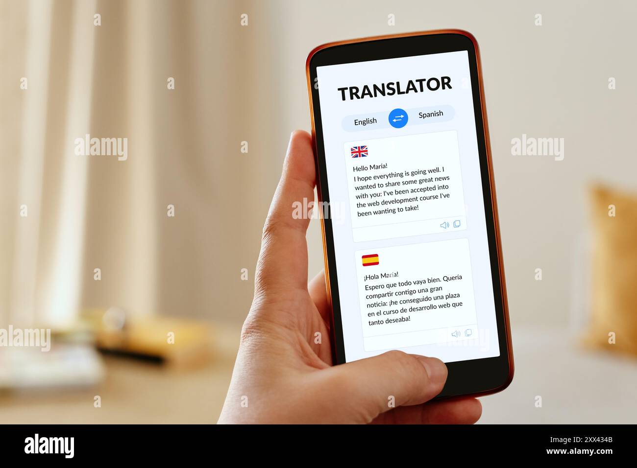 Mano femminile che tiene in mano uno smartphone mobile che visualizza un'app per traduttori linguistici. Foto Stock