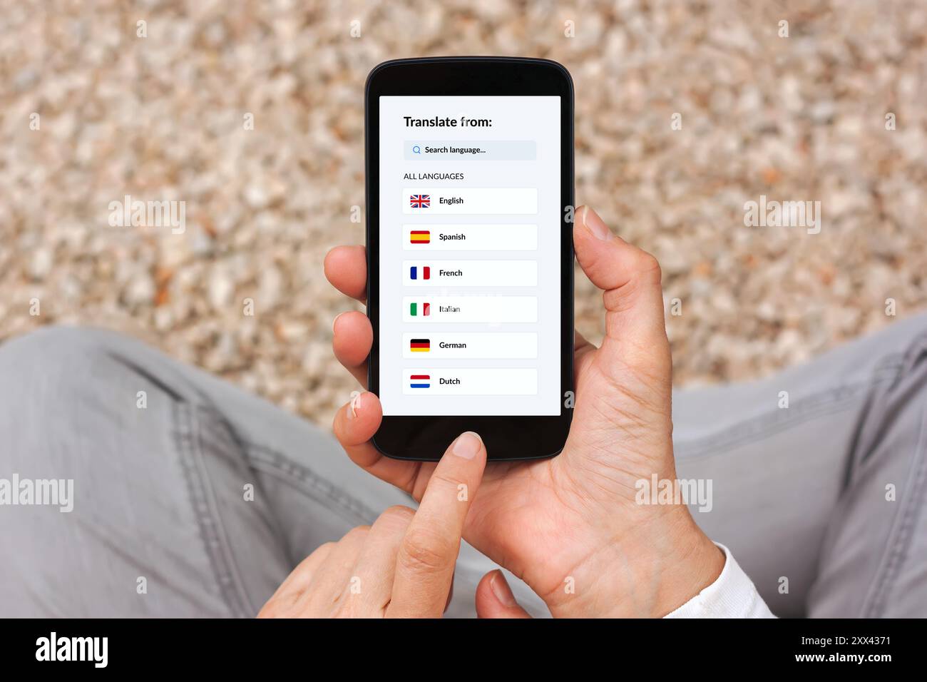 Mani che tengono in mano lo smartphone con il concetto di app per traduttori linguistici sullo schermo. Posizione piatta Foto Stock