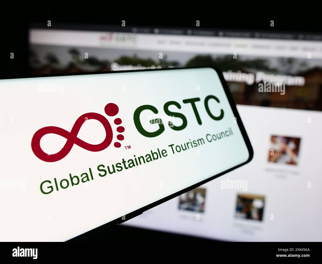 Smartphone con logo dell'organizzazione Global Sustainable Tourism Council (GSTC) davanti al sito Web. Mettere a fuoco la parte centrale sinistra del display del telefono. Foto Stock