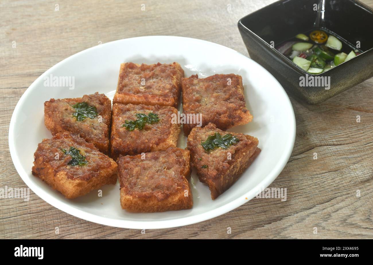 Toast di maiale fritti croccanti sul piatto mangiate una coppia con salsa di verdure sottaceto Foto Stock