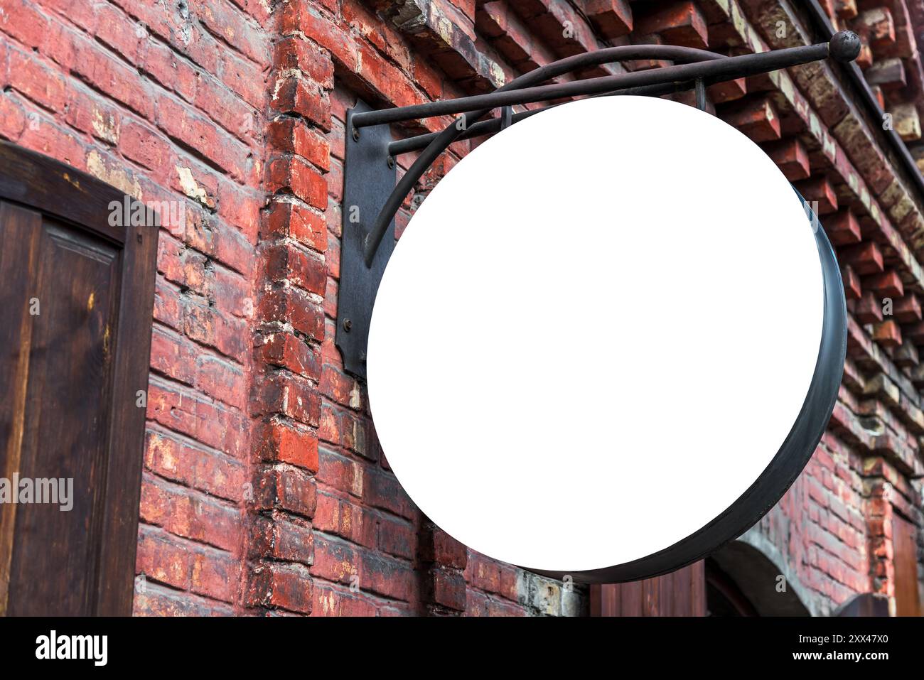 Bianco bianco Mockup di Street Store cartello Vintage su una vecchia parete di mattoni rossi. Segno rotondo vuoto per la vendita al dettaglio per logo o marchio Foto Stock