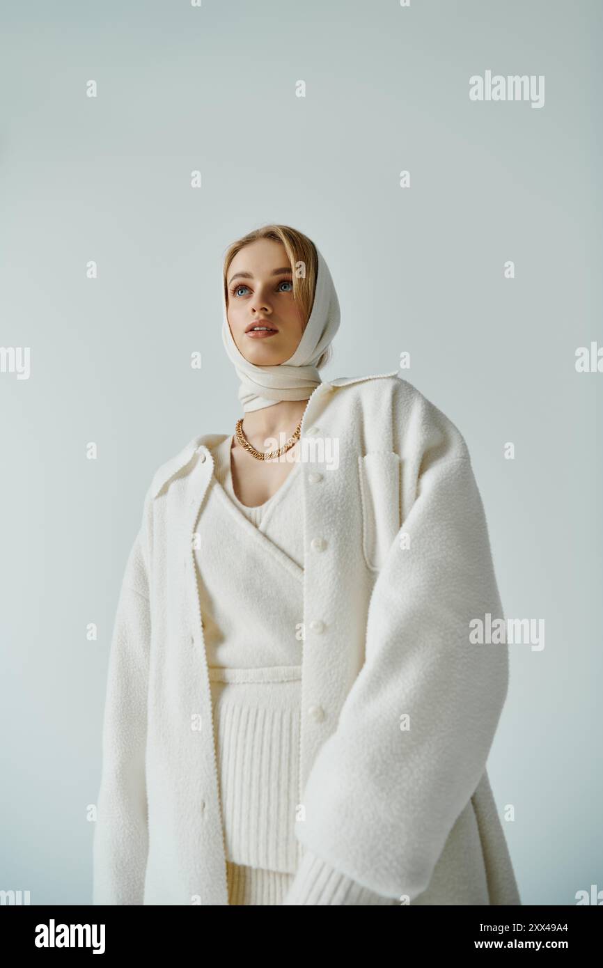 Giovane donna in abito bianco, persa nel pensiero, guarda in alto. Foto Stock