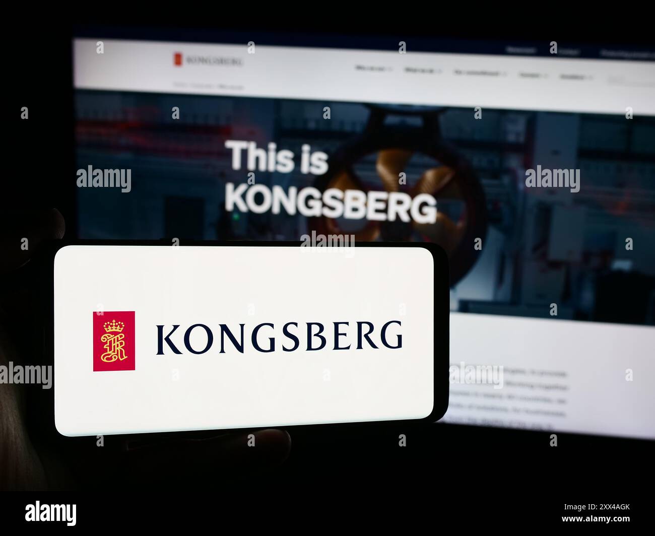Persona che detiene un telefono cellulare con il logo della società norvegese Kongsberg Gruppen ASA di fronte alla pagina web aziendale. Mettere a fuoco il display del telefono. Foto Stock