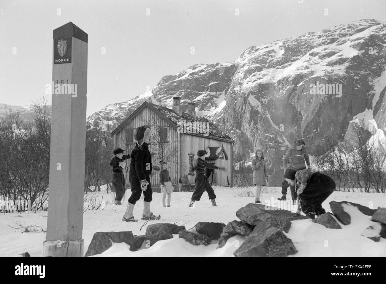 Attuale 08-1949: Niente di nuovo dal confine a nord. Una striscia di neve vergine lunga 160 chilometri, che collega lo sbocco di Grense Jakobselv a Grensefoss a Pasvikdalen, sarà l'unico confine comune tra i paesi del Patto Atlantico e l'Unione Sovietica quando la Norvegia aderirà al Patto A. Al momento sono andati lungo il confine e hanno parlato con le persone che vivono lì. Folkeskolen a Grense Jakobselv è il più orientale del paese. L'Aia si estende fino ai posti di confine, e le urla dei bambini che giocano possono essere sicuramente ascoltate fino all'Unione Sovietica. La scuola è divisa in due par Foto Stock