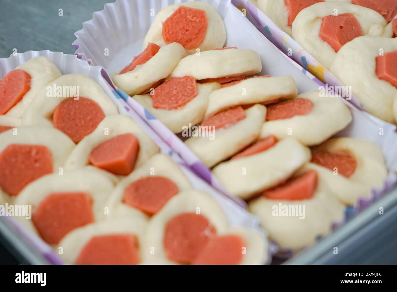 Panino con salsicce inserito in una lunga tazza di carta da forno. Foto Stock
