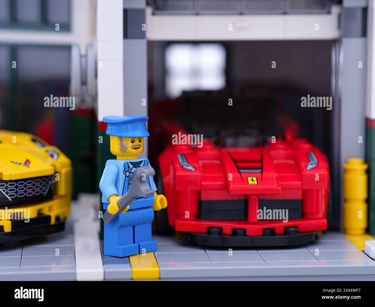 Tambov, Federazione Russa - 17 luglio 2024 Una minifigura meccanica Lego in piedi di fronte a un garage con una Ferrari all'interno Foto Stock