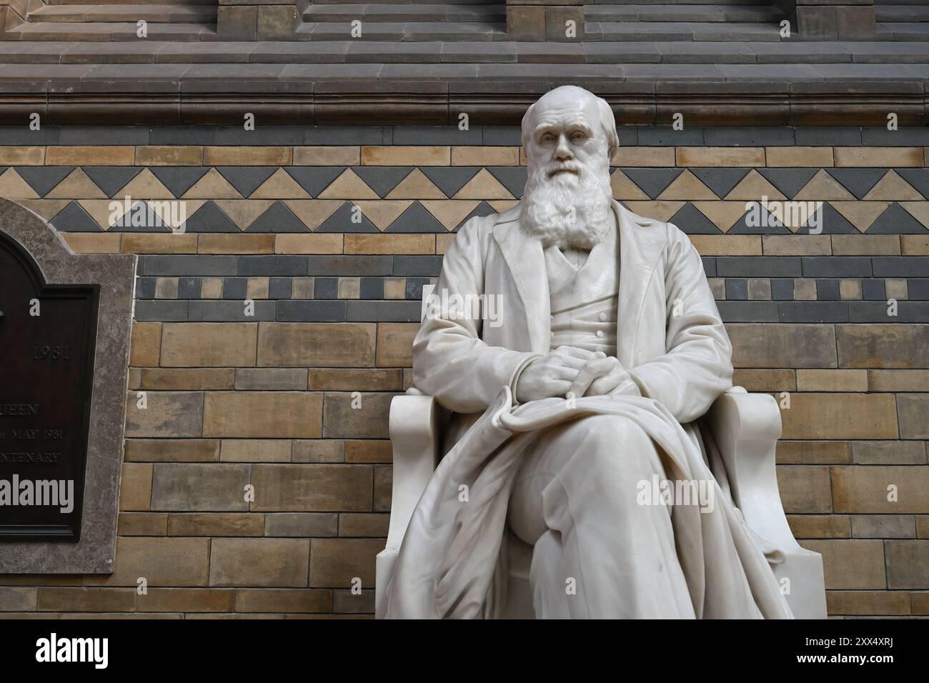Una statua in marmo di Charles Darwin che si affaccia sulla Hintze Hall nel Museo di storia naturale di Londra, inaugurata nel 1885 Foto Stock