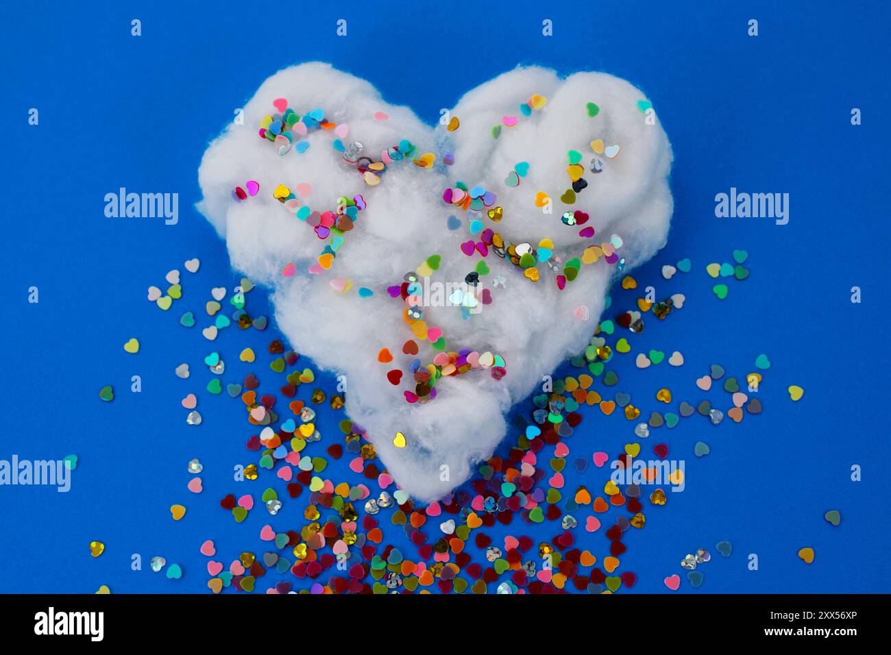 Pioggia di cuori colorati che cadono da una nuvola di cotone Foto Stock