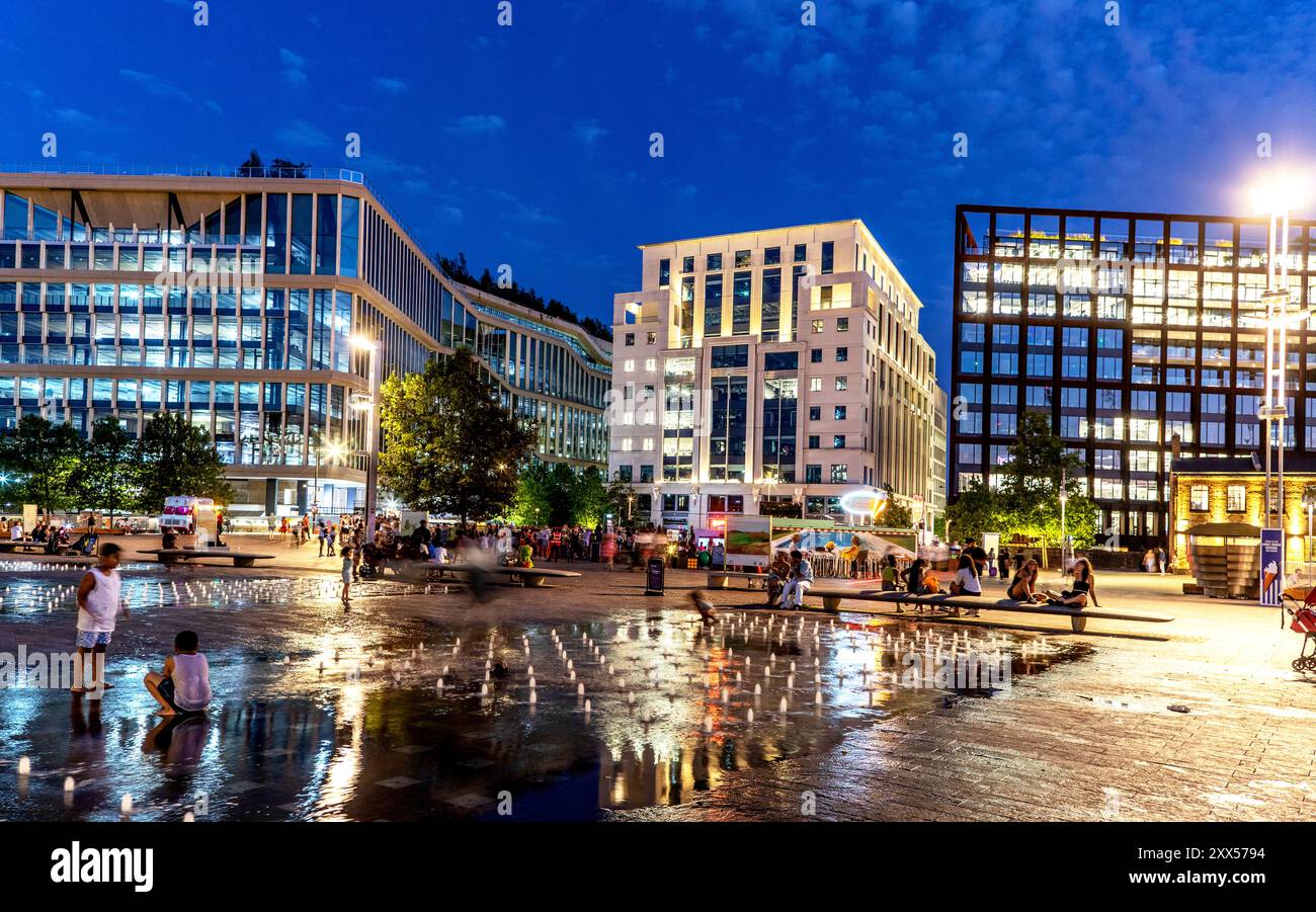 Persone che suonano nelle fontane di Night Kings Cross Development Londra Regno Unito Foto Stock