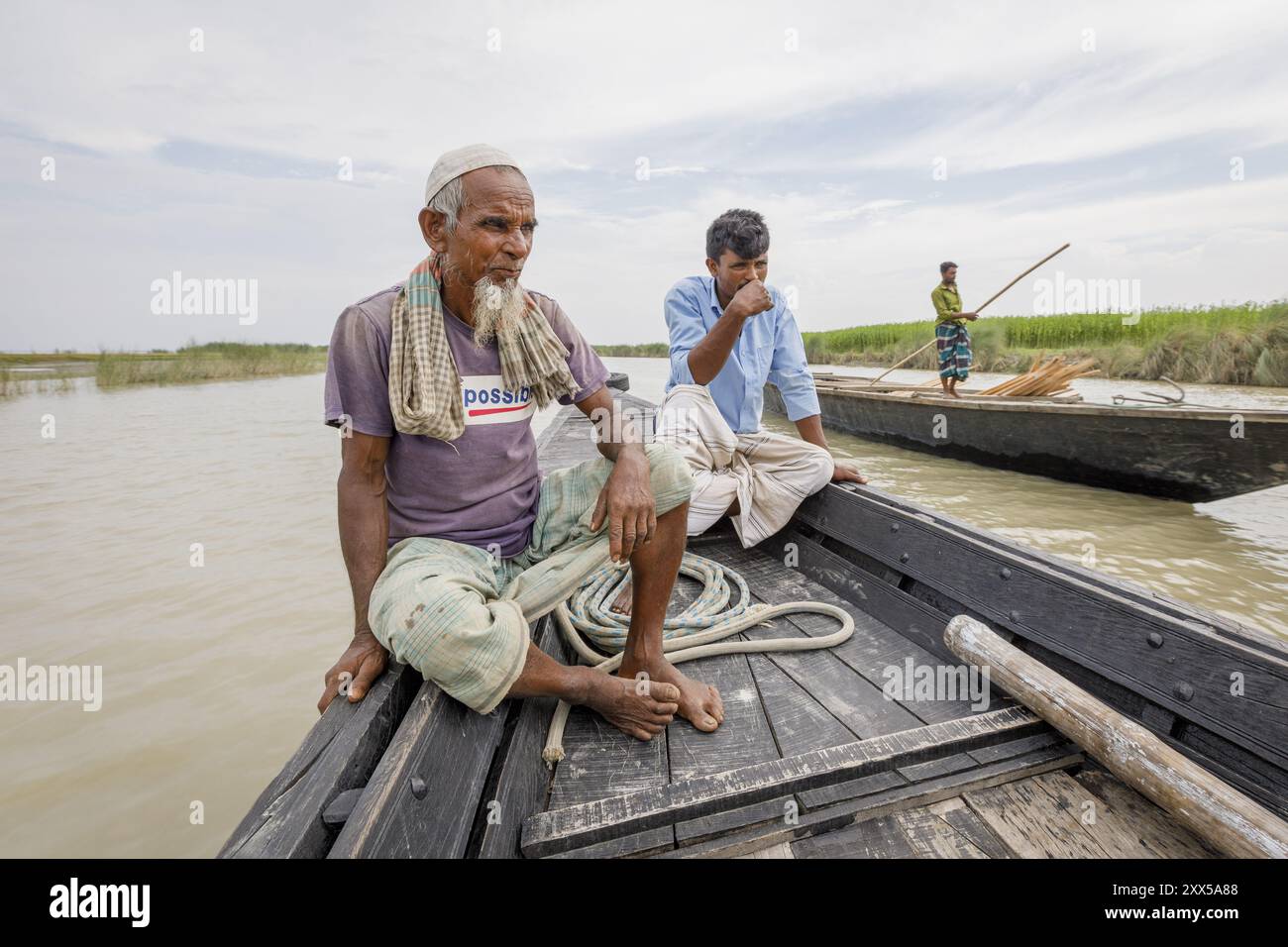 Il proprietario del negozio Mizanur Rahman e il suo ex vicino Abdul Bari ci hanno portato nella loro casa precedente a Bhandar, che hanno dovuto abbandonare quando l'erosione del fiume ha spazzato via il terreno sottostante. Entrambi ora vivono sul basamento di Nayer Char. Foto Stock