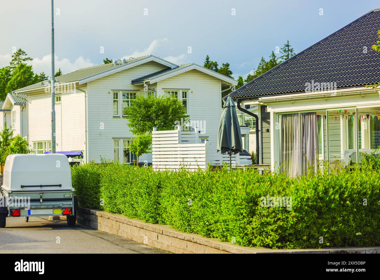 Moderne ville in legno a due piani con design paesaggistico nella comunità europea, con roulotte parcheggiate sulla strada. Svezia. Foto Stock