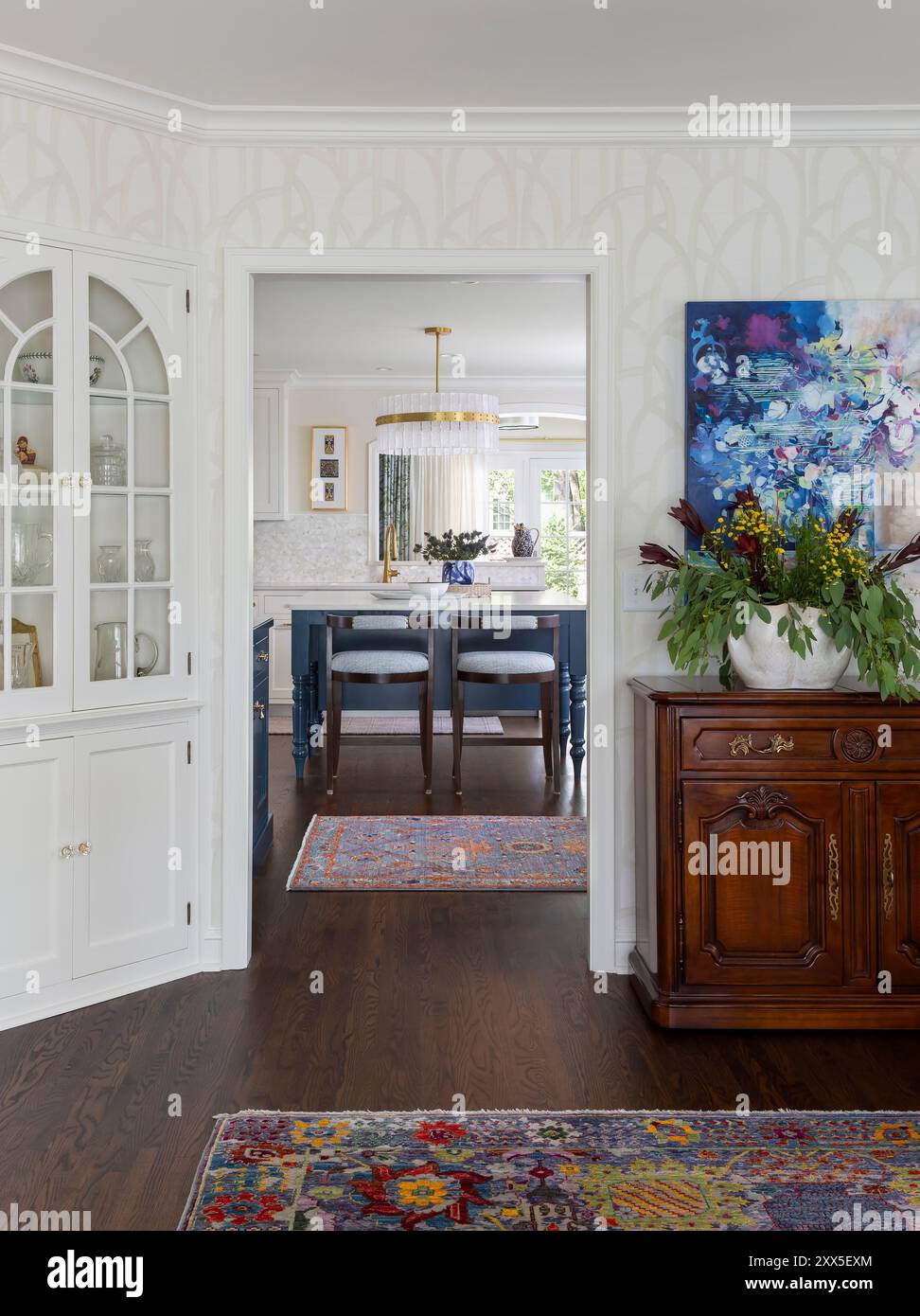 Vista sulla cucina dalla sala da pranzo con armadietto in porcellana incorporato con porte in vetro semicircolari Foto Stock