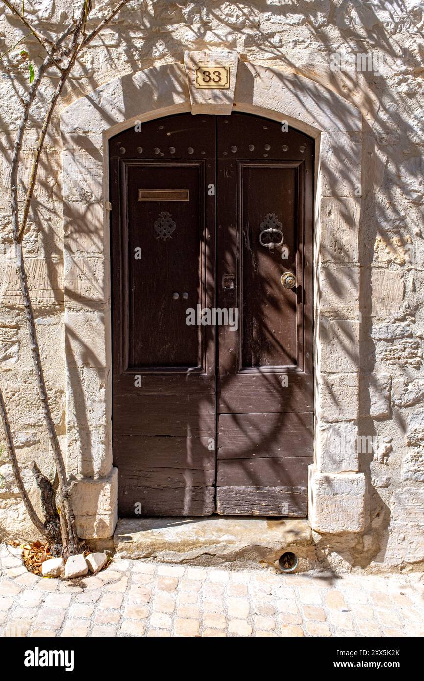 Una vecchia porta marrone di un edificio in pietra, preso a Vezenorbes, Provenza, Francia, in una soleggiata giornata di agosto Foto Stock