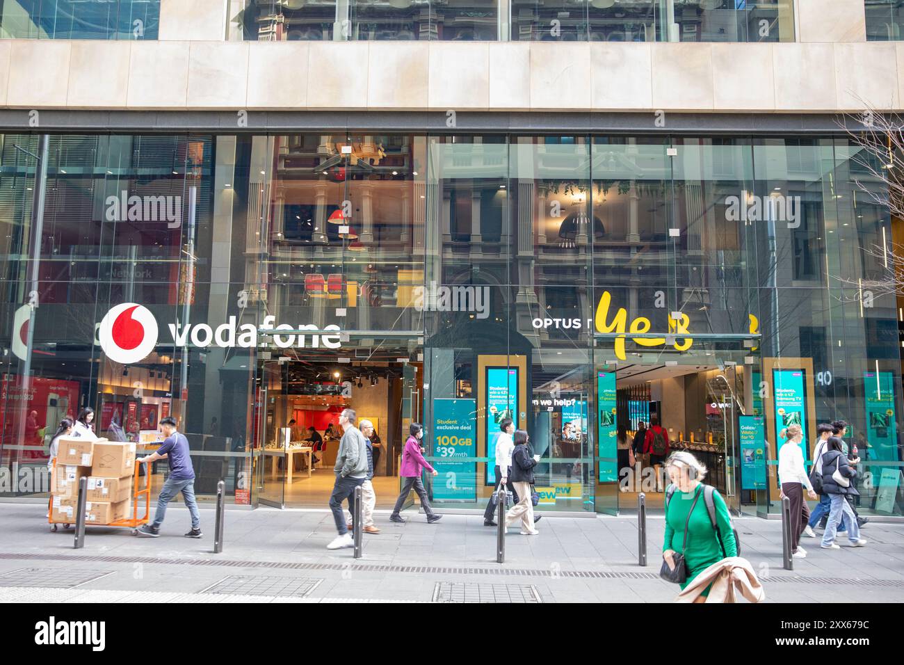 I negozi di telecomunicazioni Vodafone e Optus Sid eby Side in George Street, nel centro di Sydney, New South Wales, Australia, con gli amanti dello shopping che passano davanti ai negozi Foto Stock