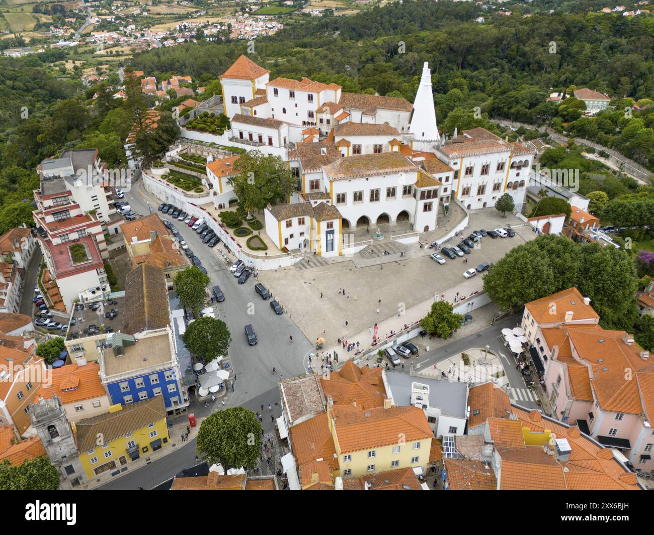 Vista dall'alto di una città idilliaca con molti tetti bianchi e colorati, circondata da alberi e colline, vista aerea, Palazzo reale, Palacio Nacional de Foto Stock