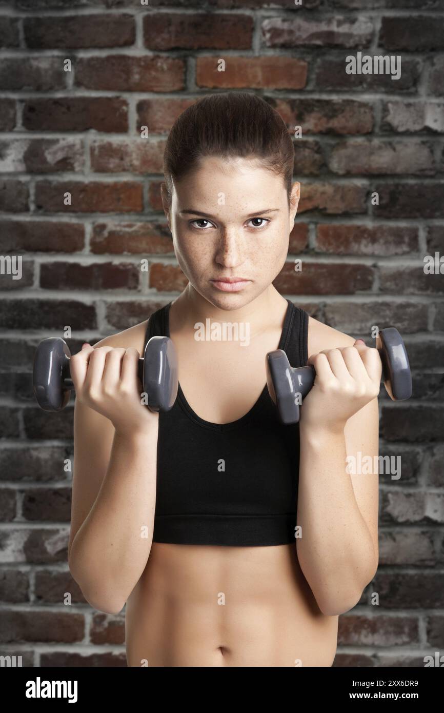 La donna che lavora fuori con manubri in palestra Foto Stock