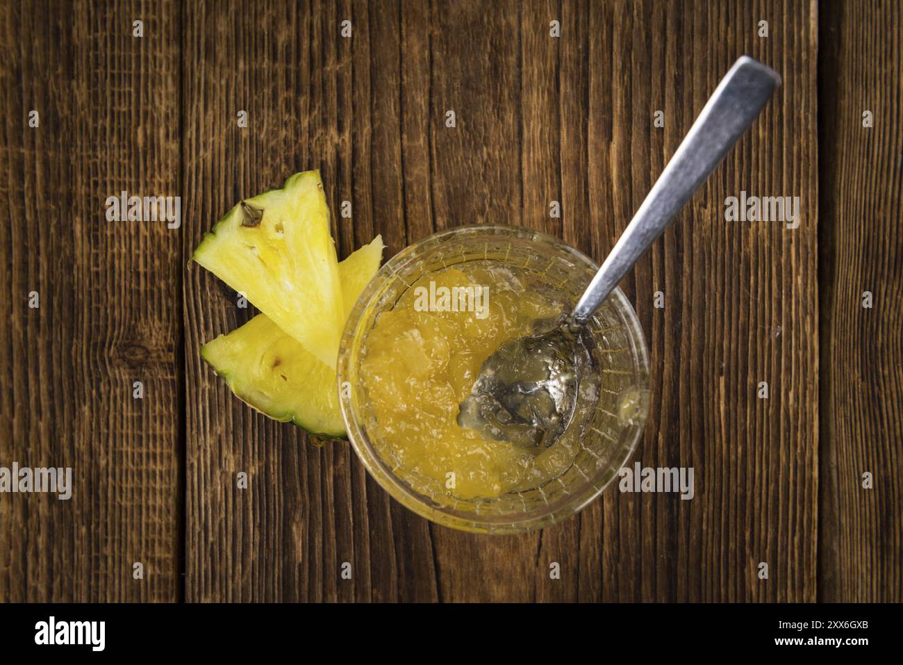 Marmellata di ananas appena preparata su un vecchio e rustico tavolo in legno, messa a fuoco selettiva, primo piano Foto Stock
