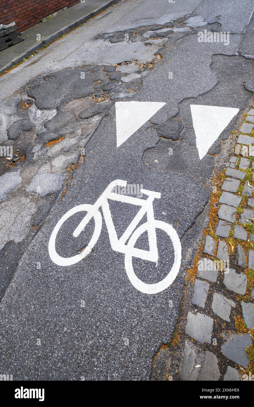 Un pittogramma di una pista ciclabile su una strada con buche a Moenchengladbach, Germania, Europa Foto Stock