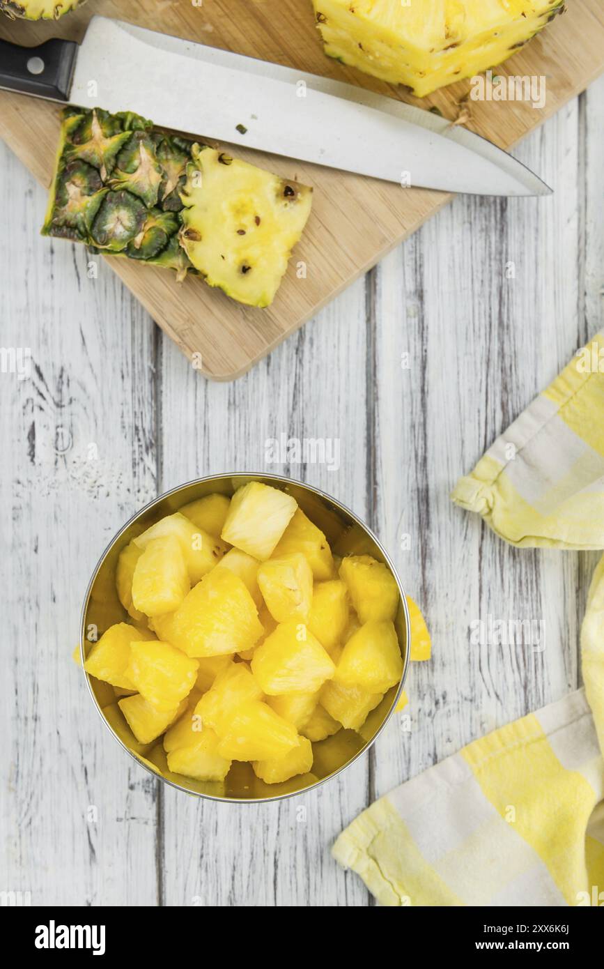 L'ananas tagliato a fette su un vecchio tavolo di legno come primo piano dettagliato, messa a fuoco selettiva Foto Stock