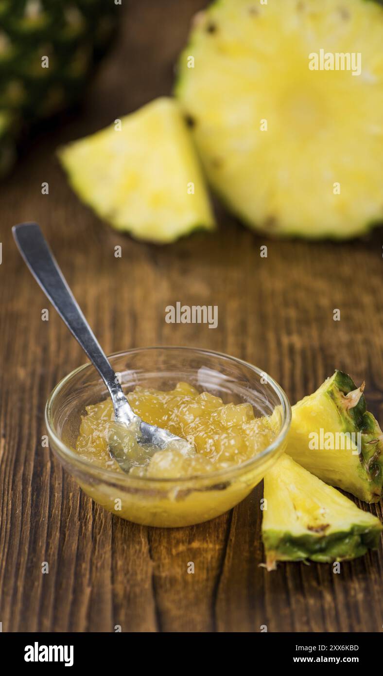 Marmellata di ananas appena preparata su un vecchio e rustico tavolo in legno, messa a fuoco selettiva, primo piano Foto Stock