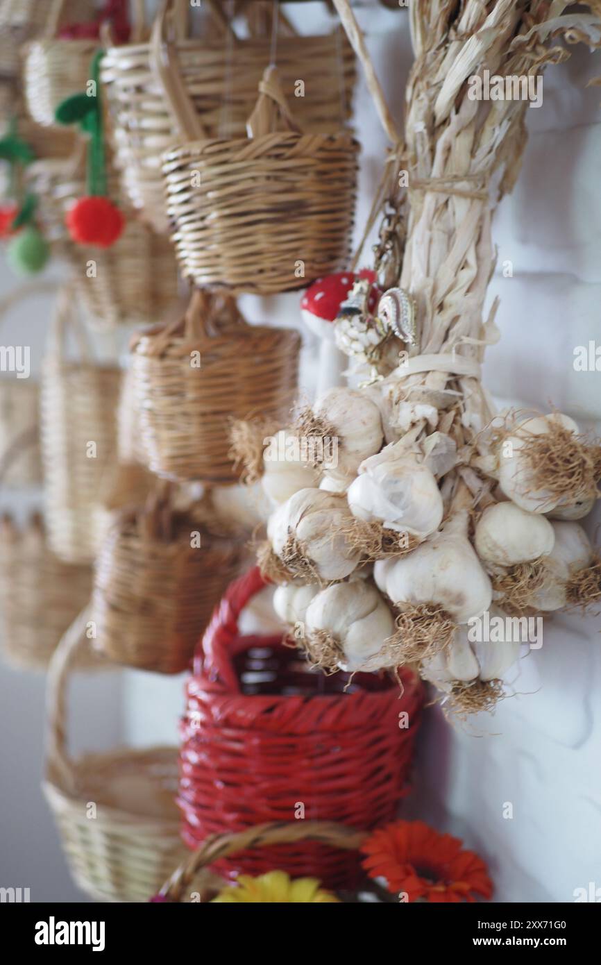 Uno splendido mazzo di aglio è appeso in cucina come parte del tema dell'arredamento della casa Foto Stock