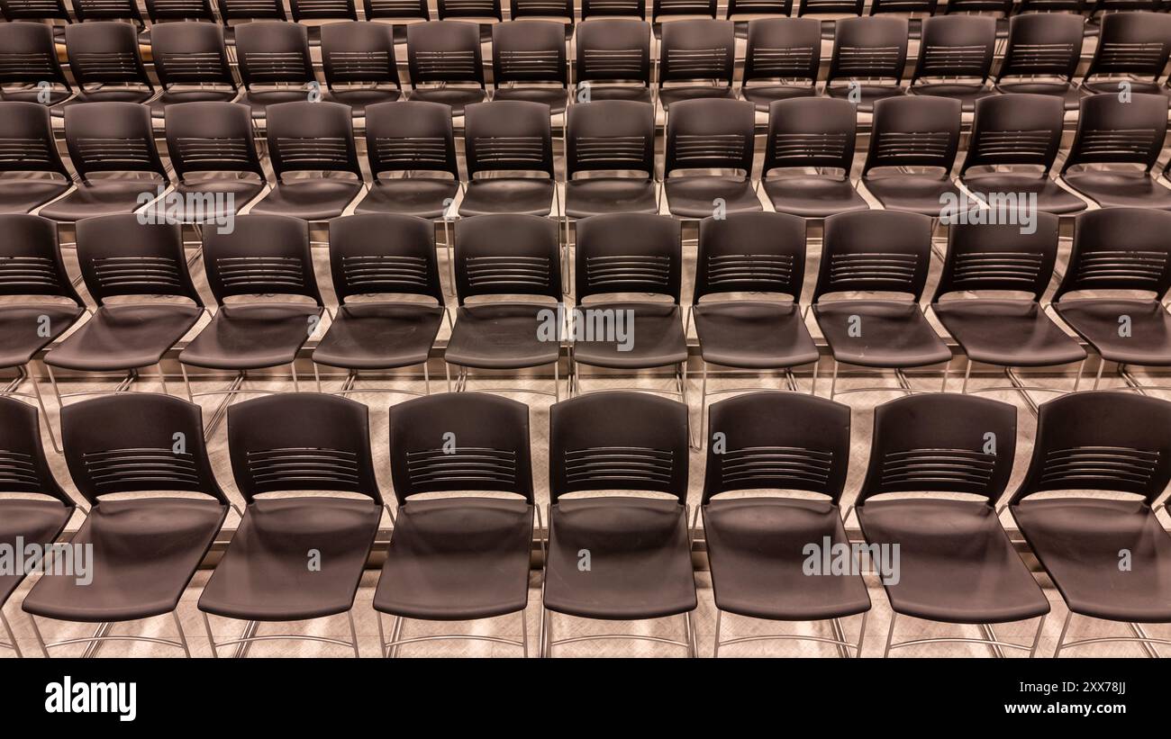 Foto di un nuovo teatro scolastico, auditorium, ampio spazio didattico per gruppi con posti a sedere grigi, sedie. Foto Stock