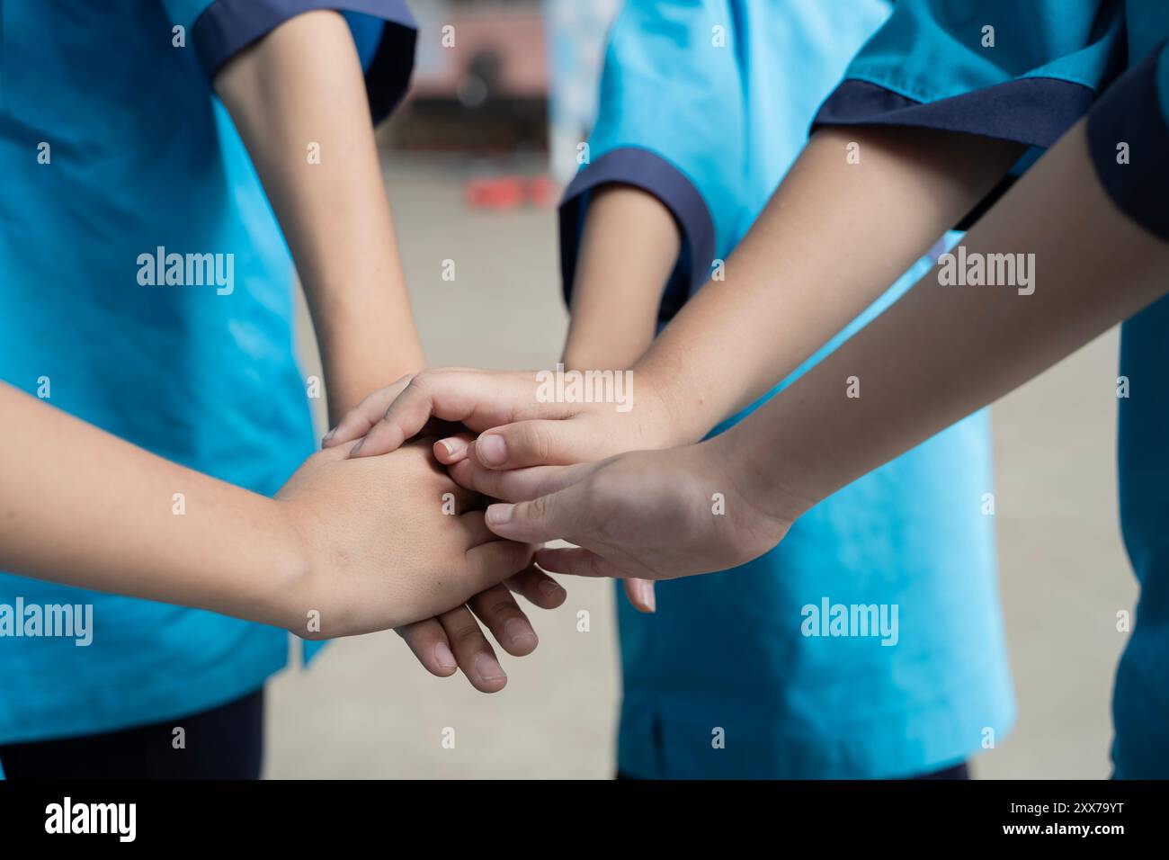 Primo piano di adulti e bambini che impilano le mani all'esterno. Bambini piccoli che tengono le mani insieme all'interno. Concetto di unità Foto Stock