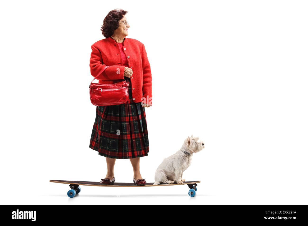 Donna anziana con un cane che cavalca una longboard isolata su sfondo bianco Foto Stock