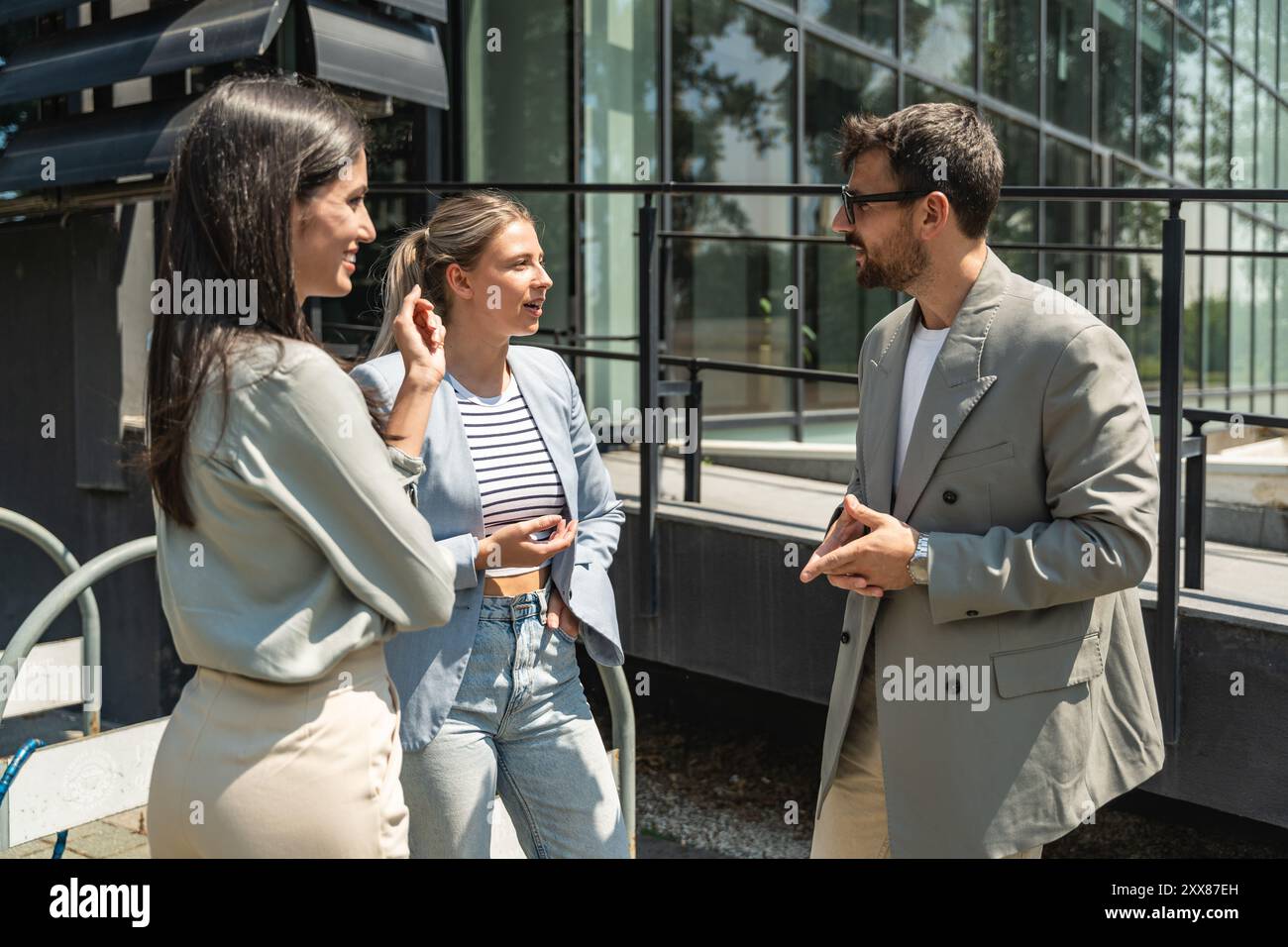 Scambio di abilità di squadra. Gruppo di giovani imprenditori che lavorano su idee al di fuori degli uffici. Uomo d'affari e donna d'affari che discutono e p Foto Stock