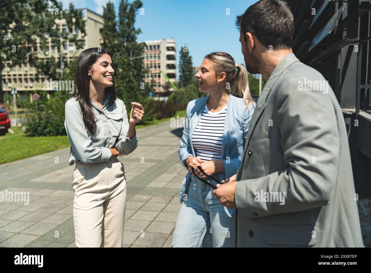 Scambio di abilità di squadra. Gruppo di giovani imprenditori che lavorano su idee al di fuori degli uffici. Uomo d'affari e donna d'affari che discutono e p Foto Stock