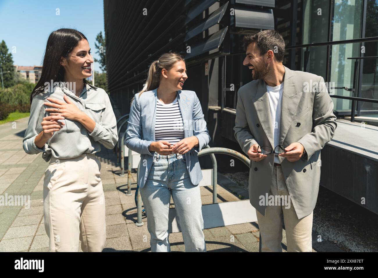 Scambio di abilità di squadra. Gruppo di giovani imprenditori che lavorano su idee al di fuori degli uffici. Uomo d'affari e donna d'affari che discutono e p Foto Stock