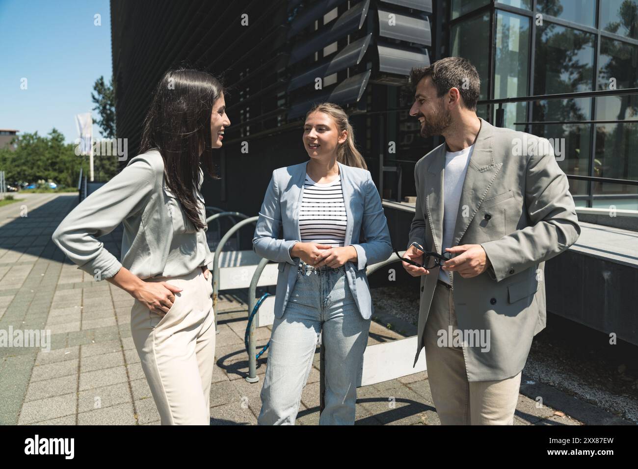 Scambio di abilità di squadra. Gruppo di giovani imprenditori che lavorano su idee al di fuori degli uffici. Uomo d'affari e donna d'affari che discutono e p Foto Stock