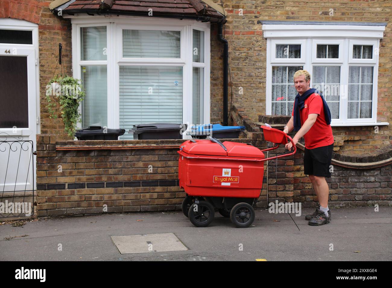 CROYDON, Regno Unito - 8 LUGLIO 2024: Corriere a mano della Royal mail che consegna la posta a Croydon, Regno Unito. Foto Stock