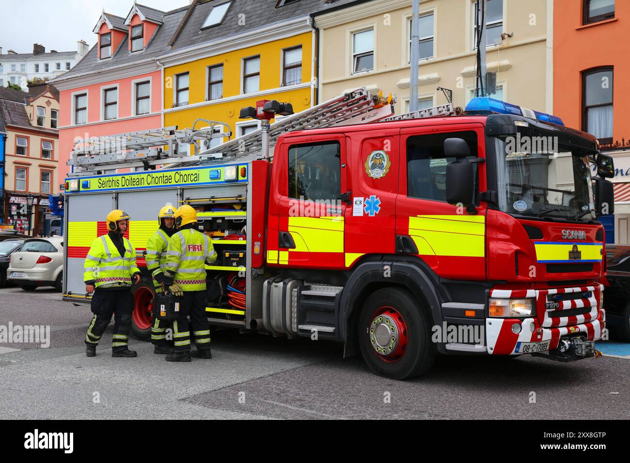 COBH, IRLANDA - 4 LUGLIO 2024: Vigili del fuoco in piedi accanto al camion dei pompieri Scania nella città di Cobh, Contea di Cork in Irlanda. Foto Stock