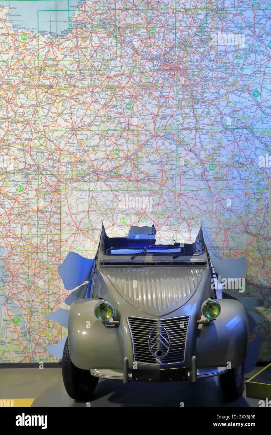 Francia, Puy de Dome, Clermont Ferrand, l'Aventure Michelin, una 2CV che colpisce una gigantesca mappa Michelin Foto Stock