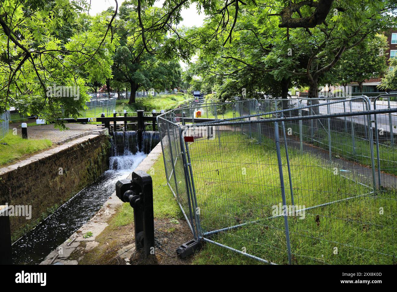 Recinzione temporanea nel parco pubblico vicino al canale di Dublino, Irlanda. La barriera consiste nel impedire ai rifugiati e agli immigrati clandestini di vivere in tende qui. Foto Stock
