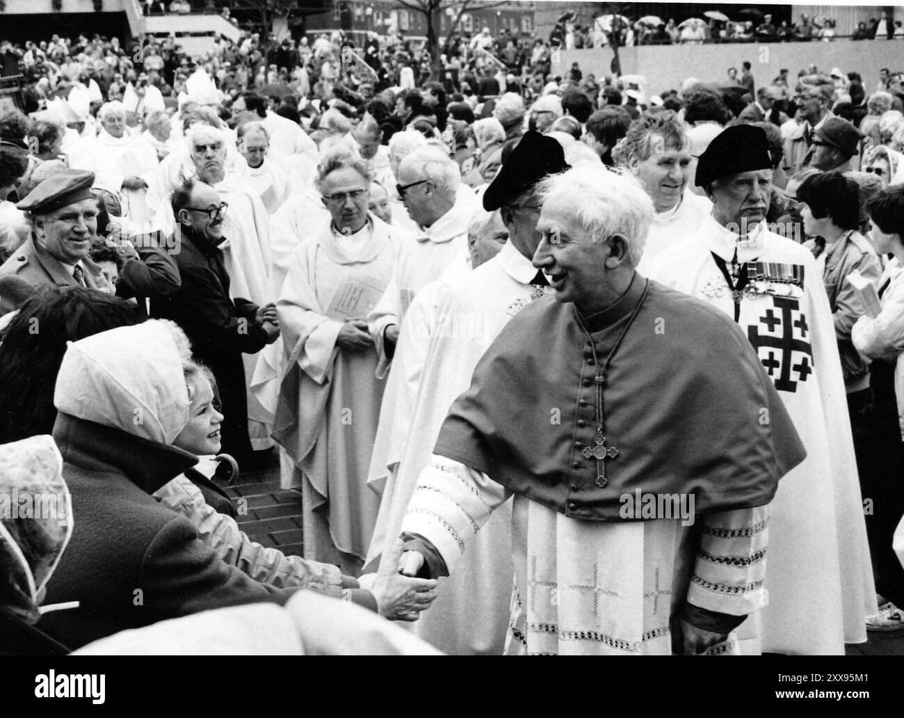 IL CARDINALE BASIL HUME CAMMINA TRA LA FOLLA ALLA MESSA ALL'ARIA APERTA CATTOLICA ROMANA, GUILDHALL SQUARE, PORTSMOUTH, 1983 PIC MIKE WALKER 1983 Foto Stock