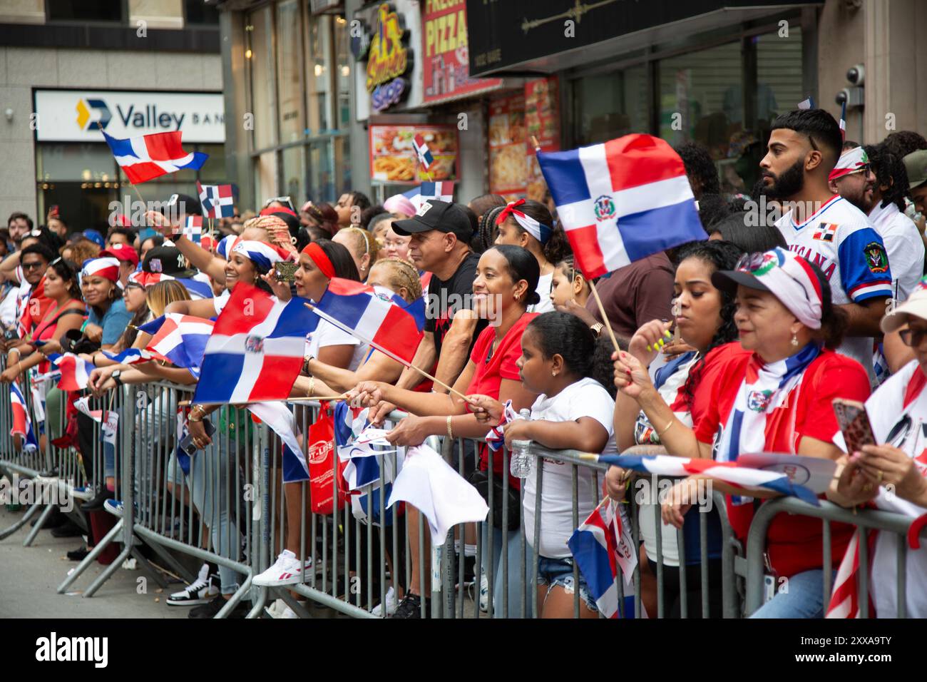 Dominican Day Parade: Folle di spettatori entusiasti si sono manifestate per la Dominican Day Parade sulla 6th Avenue nel centro di Manhattan, New York City. Foto Stock