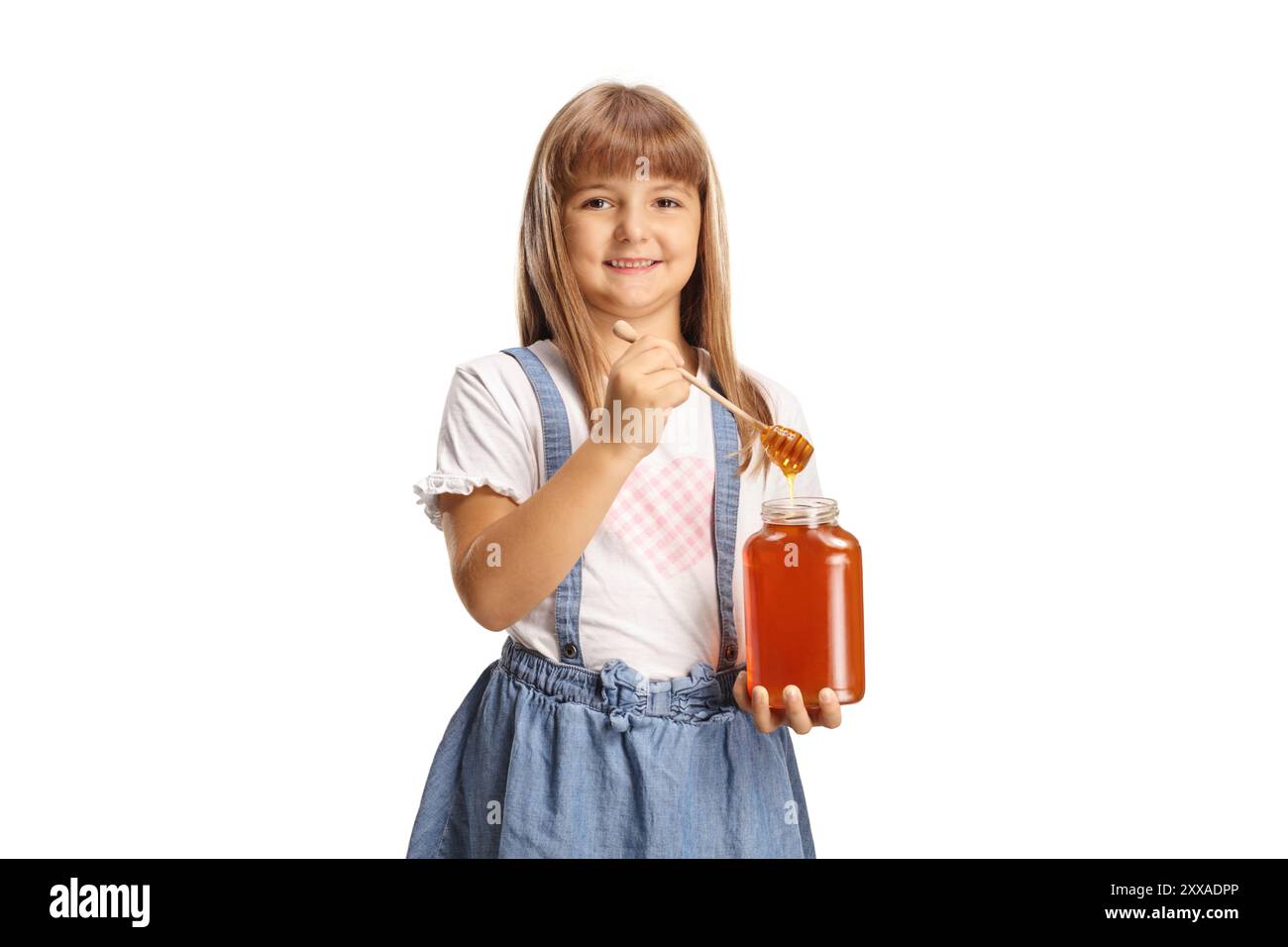 Bambina felice che tiene in mano un barattolo di miele isolato su sfondo bianco Foto Stock